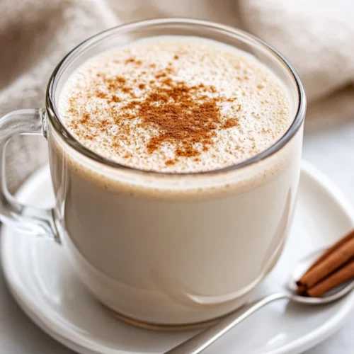 Warm Cinnamon Milk: A Cozy And Healthy Drink In Minutes 2 A Clear Mug Filled With Warm Cinnamon Milk Topped With A Sprinkle Of Cinnamon On A White Saucer