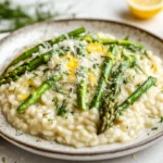 Creamy Asparagus Risotto On A Rustic White Plate Topped With Parmesan, Lemon Zest, And Dill