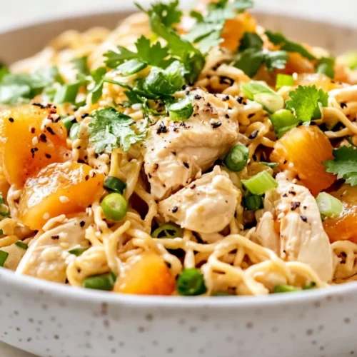 Baked Nectarine Chicken Salad In A White Bowl Topped With Crispy Noodles And Fresh Green Onions