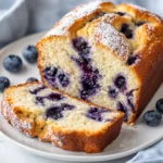 Slice Of Blueberry Cream Cheese Bread On A White Plate, Revealing Juicy Blueberries And Creamy Texture