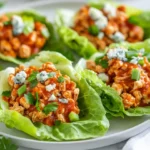 Buffalo Chicken Lettuce Wraps On A White Plate, Filled With Ground Chicken, Garnished With Blue Cheese And Parsley.