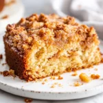 Slice Of Carrot Cake Coffee Cake On A White Plate With Golden Streusel Topping And Fresh Herbs