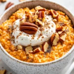 Delicious Carrot Cake Overnight Oats Topped With Yogurt, Pecans, And Maple Syrup In A White Bowl