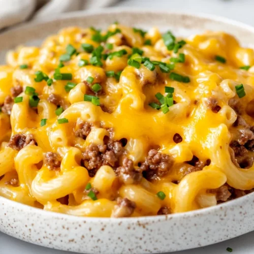 Creamy Cheeseburger Macaroni Topped With Chives On A White Plate, Showcasing A Comforting Texture And Vibrant Colors