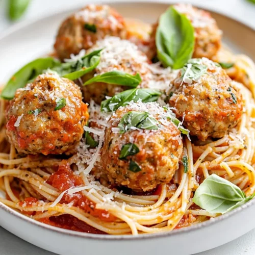 Delicious Chicken Pesto Meatballs With Whole Grain Spaghetti, Garnished With Basil And Parmesan On A White Plate.