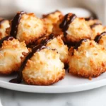 Plate Of Golden Coconut Macaroons Drizzled With Dark Chocolate, Showcasing Their Crispy Texture