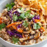 Colorful Egg Roll In A Bowl With Ground Chicken, Coleslaw, Served On A White Plate And Garnished With Cilantro.