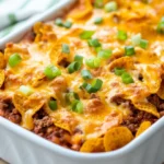 Delicious Frito Pie Casserole With Ground Beef And Melted Cheese Topped With Fritos On A White Dish
