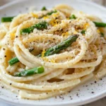 Garlic Cream Bucatini With Asparagus On A White Plate Garnished With Toasted Breadcrumbs And Lemon Zest