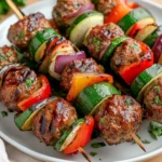 Delicious Grilled Meatball Kabobs On A White Plate With Fresh Parsley And Colorful Vegetables