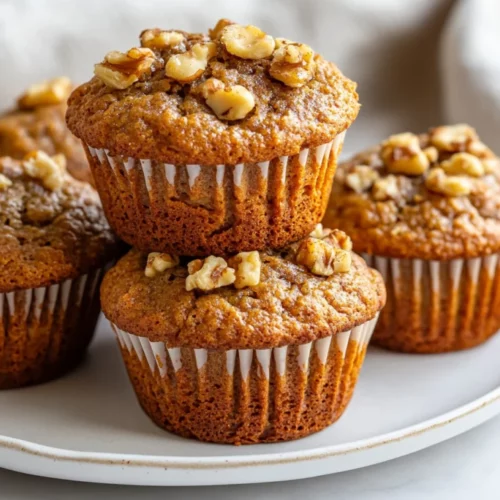 The Ultimate Healthy Banana Muffins Recipe Your Family Will Love 2 Delicious Healthy Banana Muffins On A White Plate Topped With Walnuts And Showcasing A Soft, Moist Texture