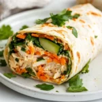 Healthy Chicken Wrap On A White Plate, Filled With Grated Vegetables And Chicken, Garnished With Parsley
