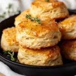 Honey Garlic Parmesan Biscuits Drizzled With Honey Butter In A Cast-Iron Skillet, Garnished With Thyme