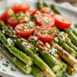 How To Cook Asparagus With Tomatoes On A White Plate Garnished With Toasted Almonds And Crumbled Blue Cheese