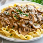 How To Make Beef Stroganoff Served On A White Plate With Fresh Parsley Over Egg Noodles And A Creamy Sauce