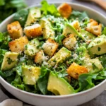 Lemon Parmesan Sesame Salad In A White Bowl Topped With Avocado, Croutons, And Sesame Seeds