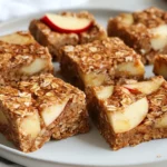 Delicious Oat And Fruit Bars On A White Plate, Garnished With Fresh Fruit Slices, Showcasing Their Chewy Texture.