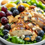Vibrant Rainbow Chicken Salad Topped With Feta And Almonds In A White Bowl, Dressed With Almond Honey Mustard