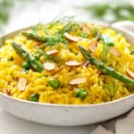 Delicious Saffron Almond Asparagus Pilaf In A White Bowl, Garnished With Fresh Herbs And Almonds