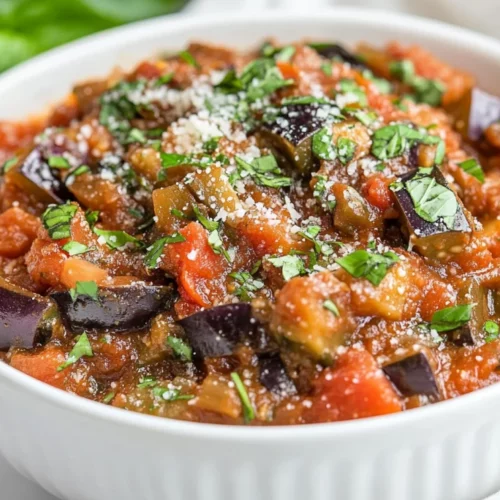 The Best Spicy Tomato Eggplant Sauce Recipe For Pasta Lovers 2 Bowl Of Spicy Tomato Eggplant Sauce Garnished With Basil And Parmesan On A Neutral Countertop