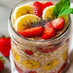 Clear Glass Jar Of Strawberry Banana Overnight Oats Topped With Fresh Fruit And Chia Seeds, Inviting And Creamy