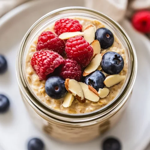 Almond Milk Overnight Oats: A Nutritious Start To Your Day 2 Jar Of Almond Milk Overnight Oats Topped With Fresh Berries And Sliced Almonds On A White Plate