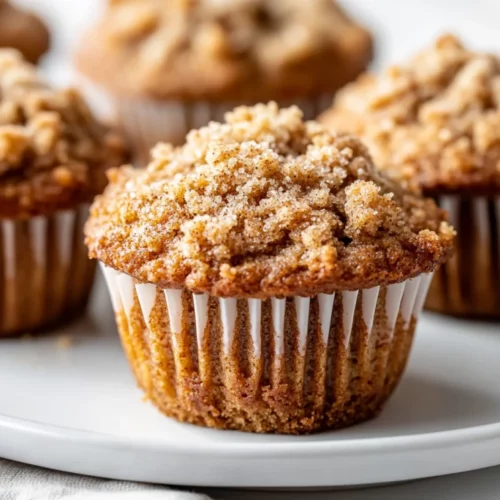 Banana Coffee Cake Muffins With Crumble Topping | Healthy &Amp; Delicious 2 Delicious Banana Coffee Cake Muffins On A White Plate With Crumble Topping, Garnished With A Sprinkle Of Cinnamon
