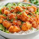Bang Bang Chicken Bowl With Crispy Chicken, Jasmine Rice, Fresh Veggies, And Creamy Sauce, Garnished With Green Onions