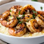 Bowl Of Cauliflower Grits With Shrimp, Topped With Parsley And Lemon On A Neutral Background