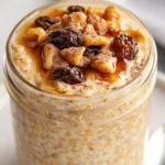 Cinnamon Raisin Overnight Oats In A Glass Jar Topped With Maple Syrup And Chia Seeds, Served On A White Plate