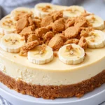 Rich And Creamy Easy Banana Pudding Cheesecake Topped With Banana Slices On A White Plate