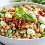 Fresh Farro Salad With Basil Dressing, Mozzarella, Beans, And Arugula In A White Bowl, Garnished With Basil
