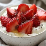Bowl Of Greek Yogurt With Strawberries Topped With Chia Seeds And A Drizzle Of Honey On A Linen Towel