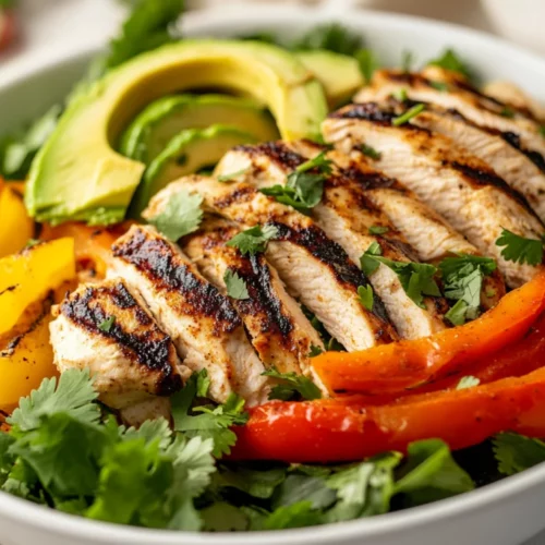 Grilled Chicken Fajita Salad In A White Bowl With Fresh Vegetables And Avocado Slices On A Neutral Background