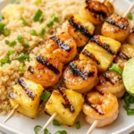 Grilled Shrimp Pineapple Kabobs On A White Plate With Coconut Quinoa, Garnished With Green Onions And Lime Wedges