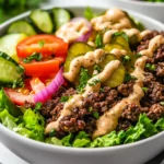 Healthy Burger Bowls With Seasoned Beef, Fresh Vegetables, And Special Sauce On A White Plate