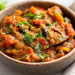 How To Make Baingan Bharta In A Rustic Bowl Topped With Fresh Cilantro On A Wooden Table