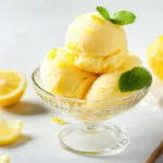 How To Make Lemon Sorbet In A Glass Bowl, Garnished With Lemon Zest And Mint On A White Background