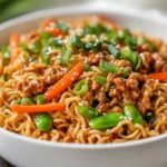 Instant Pot Ramen Stir Fry In A White Bowl, Garnished With Green Onions And Sesame Seeds