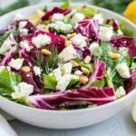 Fresh Maroulosalata Salad In A White Bowl With Feta, Pine Nuts, And Dill, Garnished With Lemon Wedges