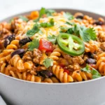 One Pot Chicken Enchilada Pasta In A Gray Bowl, Topped With Melted Cheese And Fresh Cilantro