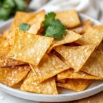 Crispy Oven Baked Tortilla Chips On A White Plate Garnished With Fresh Cilantro Leaves