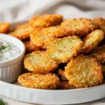 Crispy Oven-Fried Pickles Arranged On A White Plate With A Bowl Of Creamy Herb Dip On The Side