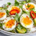 Rice Salad With Jammy Eggs Served On A White Plate, Garnished With Charred Asparagus And Coriander