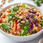 Thai Peanut Quinoa Salad In A White Bowl, Topped With Peanuts And Cilantro For Garnish