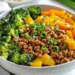 Bowl Of Turmeric Ginger Ground Turkey Bowls With Colorful Vegetables, Garnished With Green Onions And Sesame Seeds